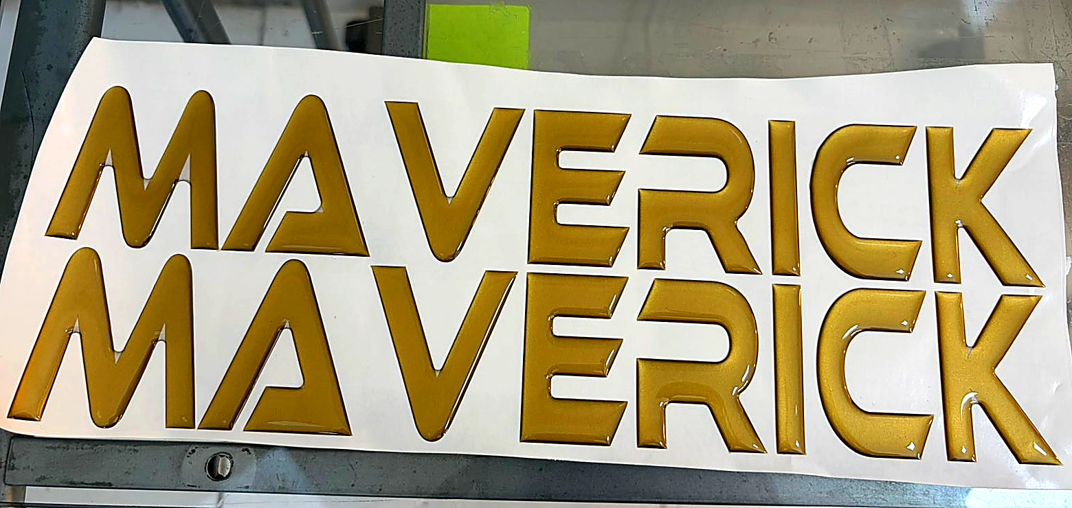 Par de adesivos resinados náuticos Maverick em dourado metálico bisotado